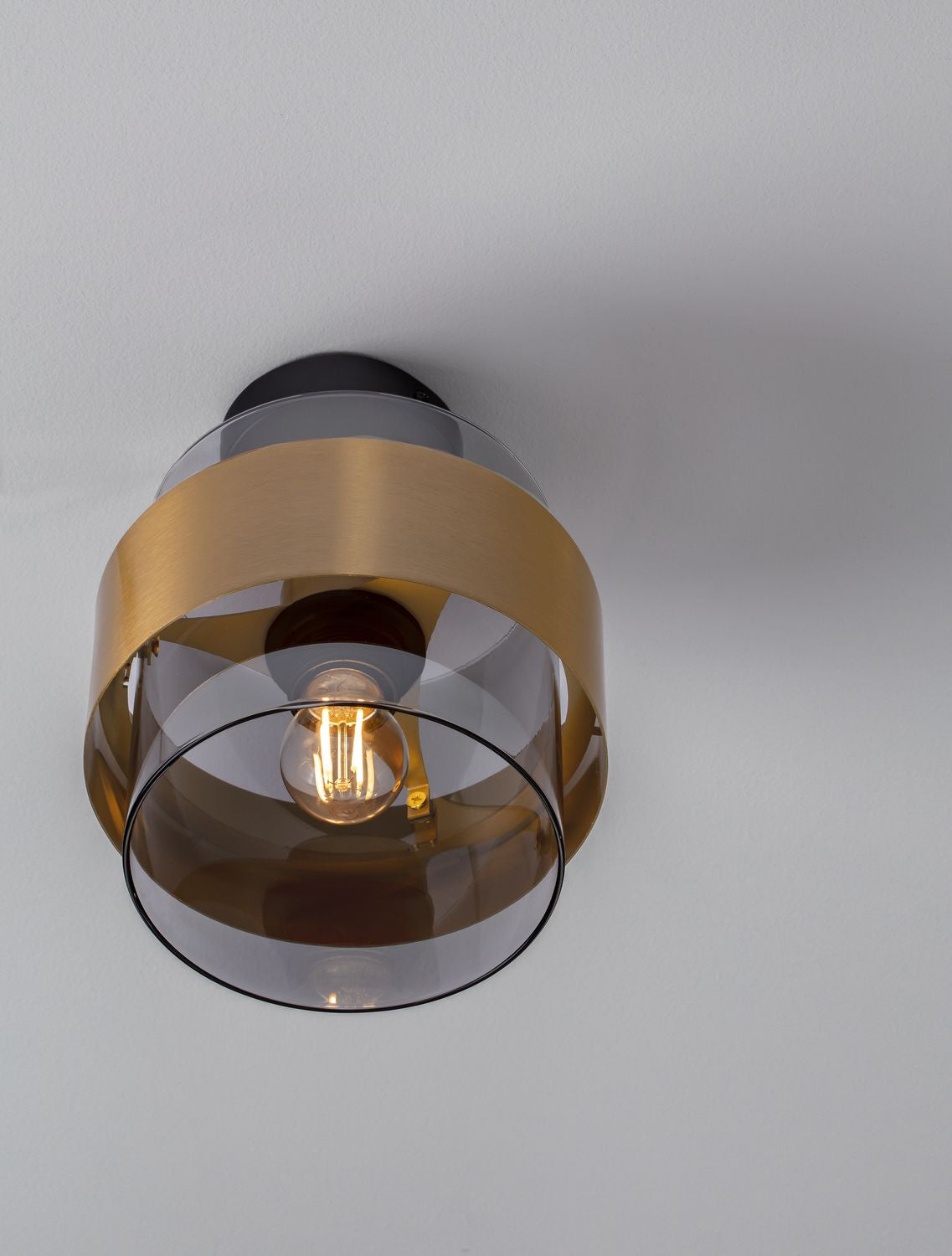 Vue en plongée depuis le plafond, abat-jour cylindrique et ampoule allumée