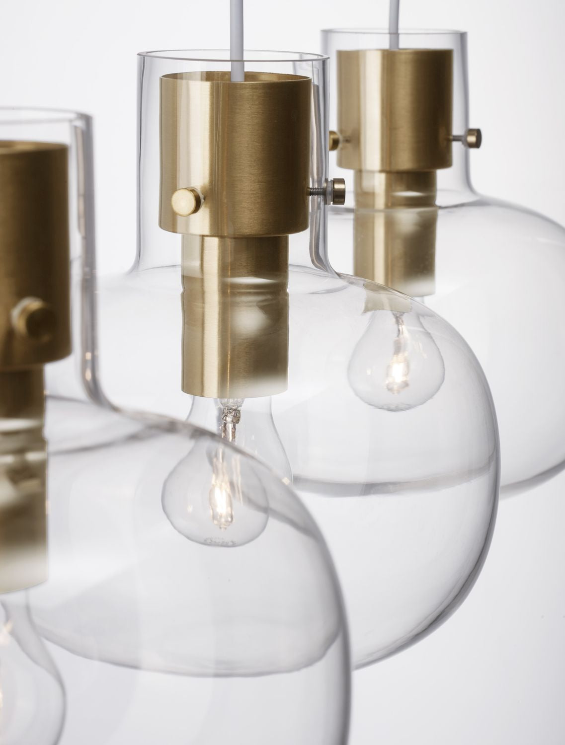 Gros plan sur la douille dorée brossée et le verre transparent du globe
