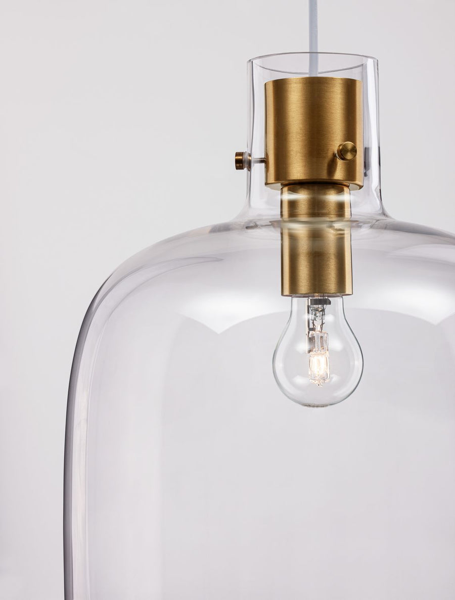 Gros plan sur la douille en laiton brossé et l'ampoule logée dans le verre