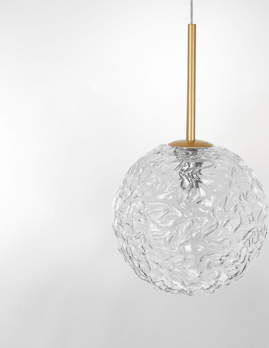 Vue rapprochée du globe en verre texturé et de sa fixation dorée