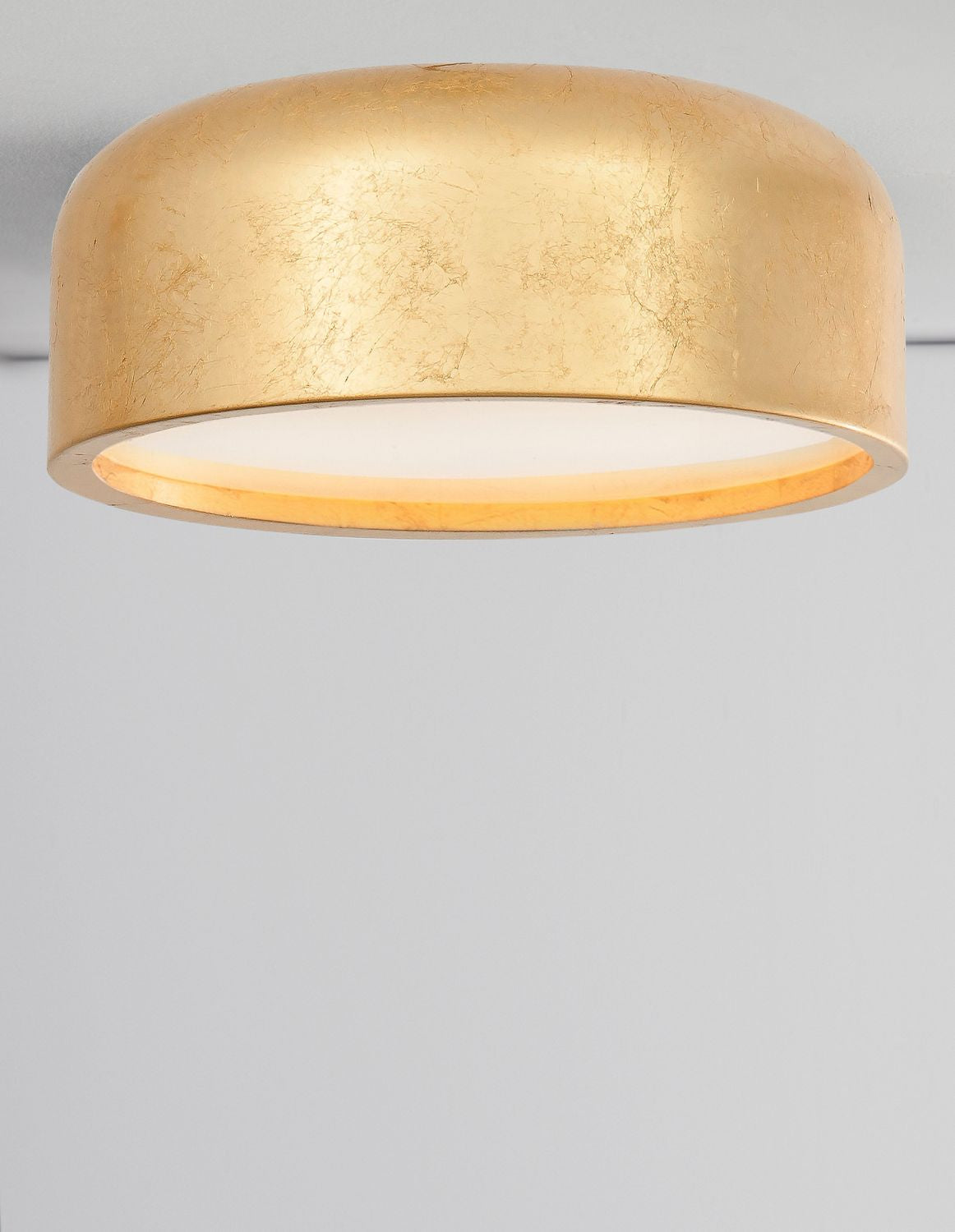 Luminaire allumé vu de face, diffuseur blanc diffusant une lumière chaude