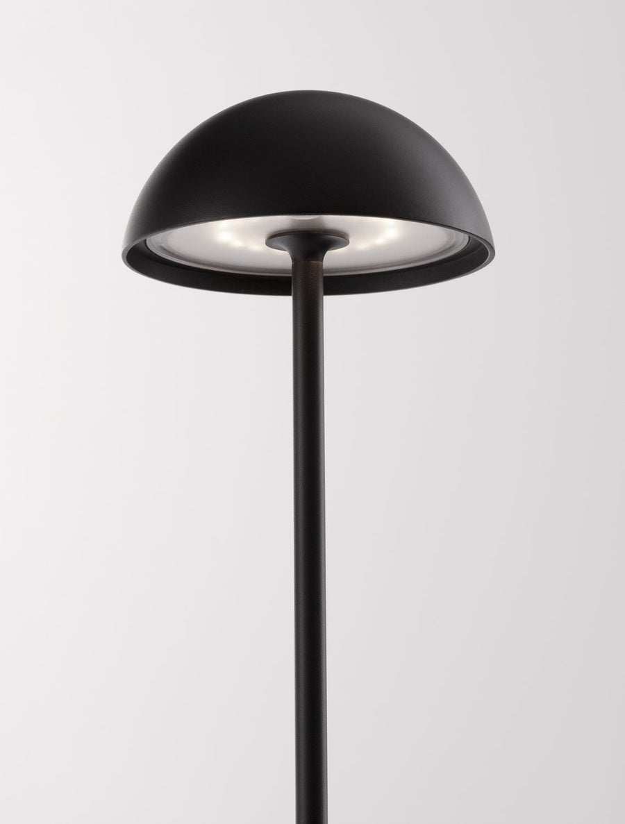 Gros plan sur l'abat-jour dôme et l'intérieur métallique de la lampe.