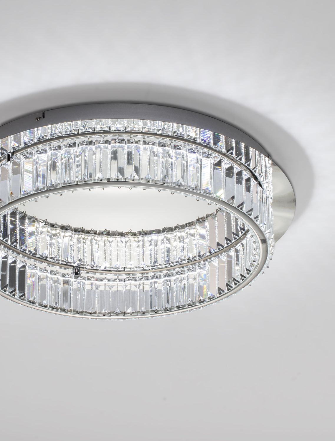 Détail rapproché des barrettes de cristal et de l'anneau métallique chromé.