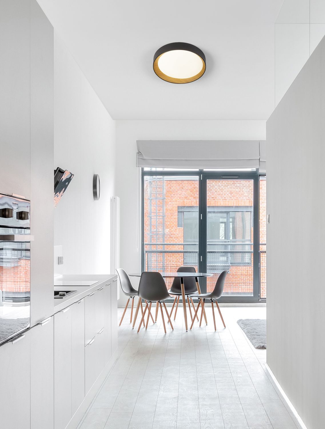 Plafonnier circulaire noir et bois installé au plafond d'une cuisine blanche moderne