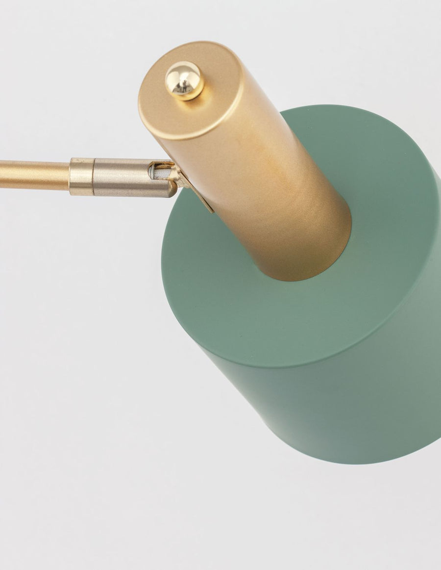 Détail du sommet doré, de l'articulation et de l'abat-jour vert de la lampe.