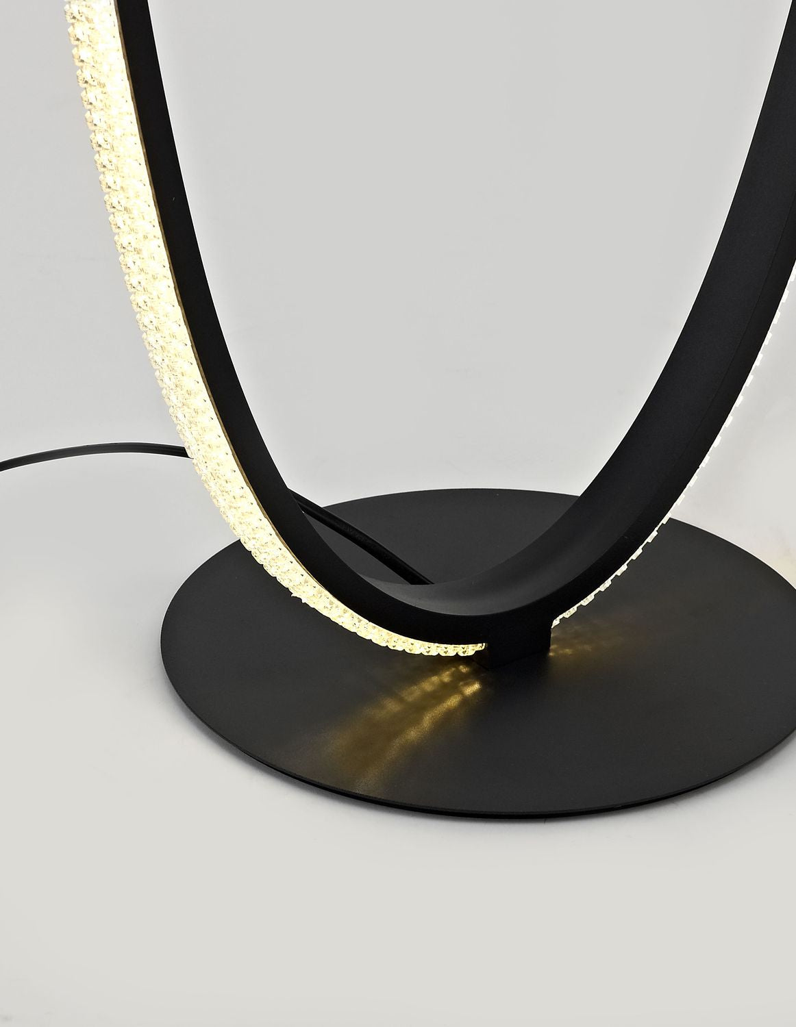 Détail du socle rond noir et de la base de l'ovale lumineux.