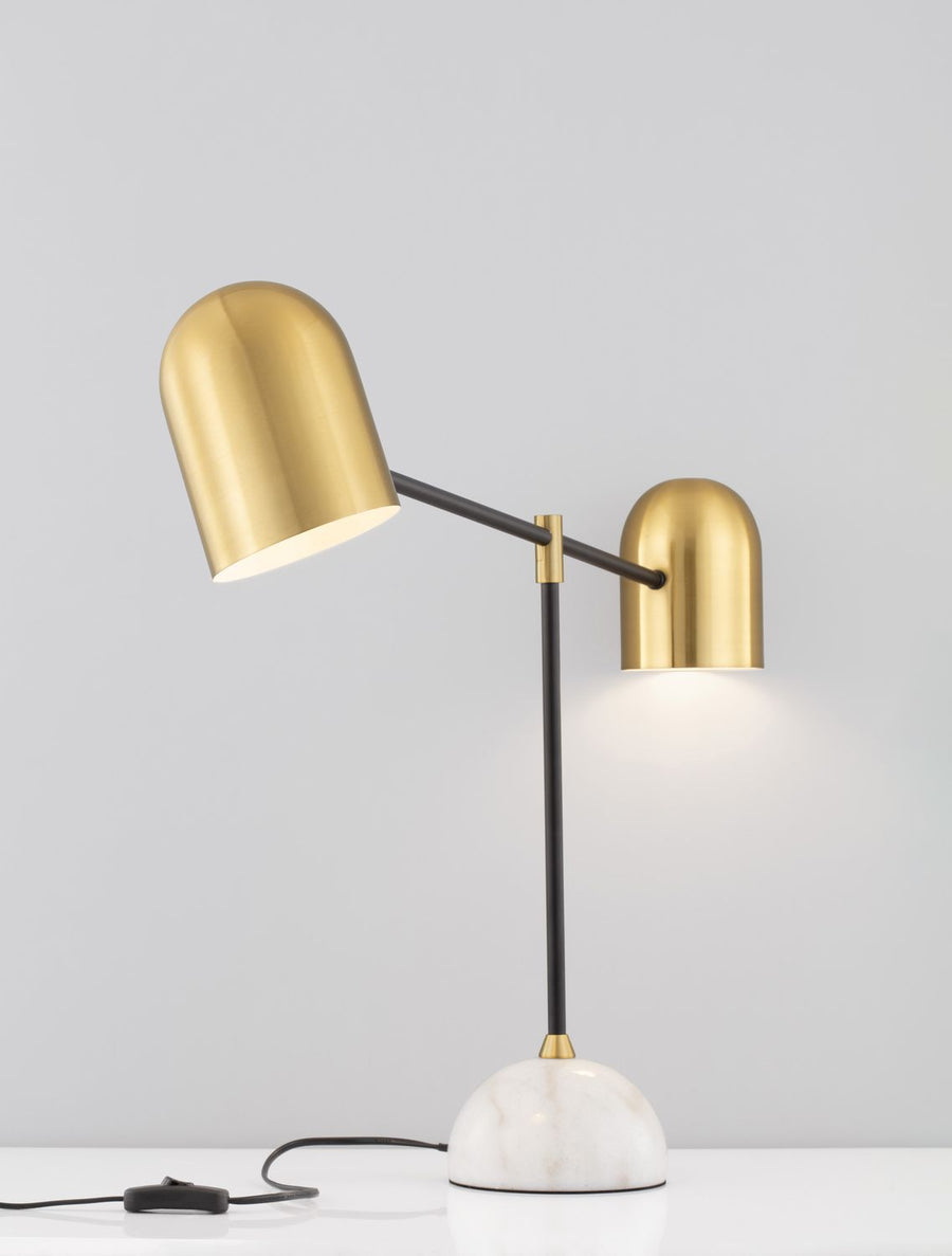 Lampe à poser deux lumières orientables, socle marbre blanc, abat-jours dorés et câble avec interrupteur.