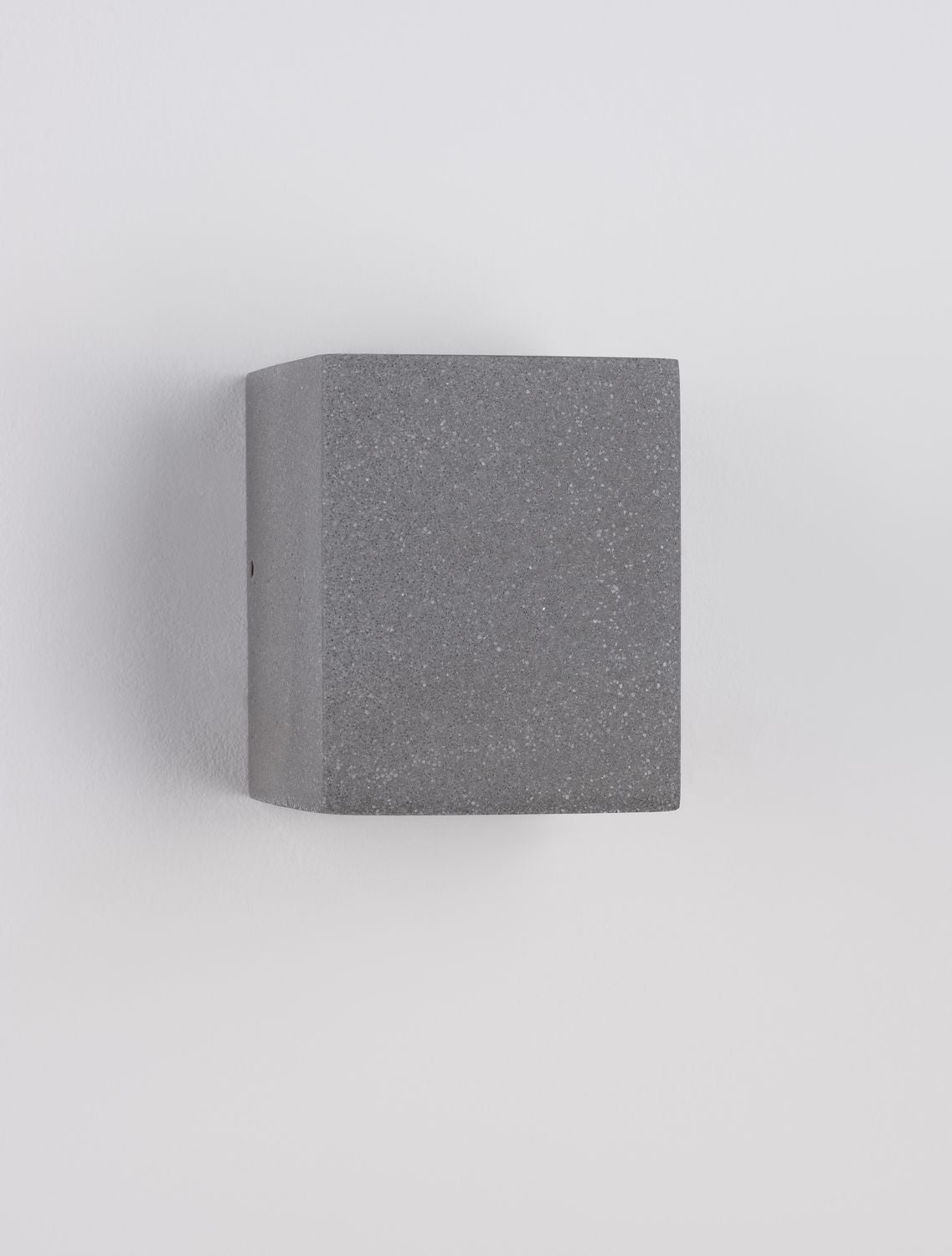 Vue de profil de l'applique grise fixée à un mur blanc, sans éclairage