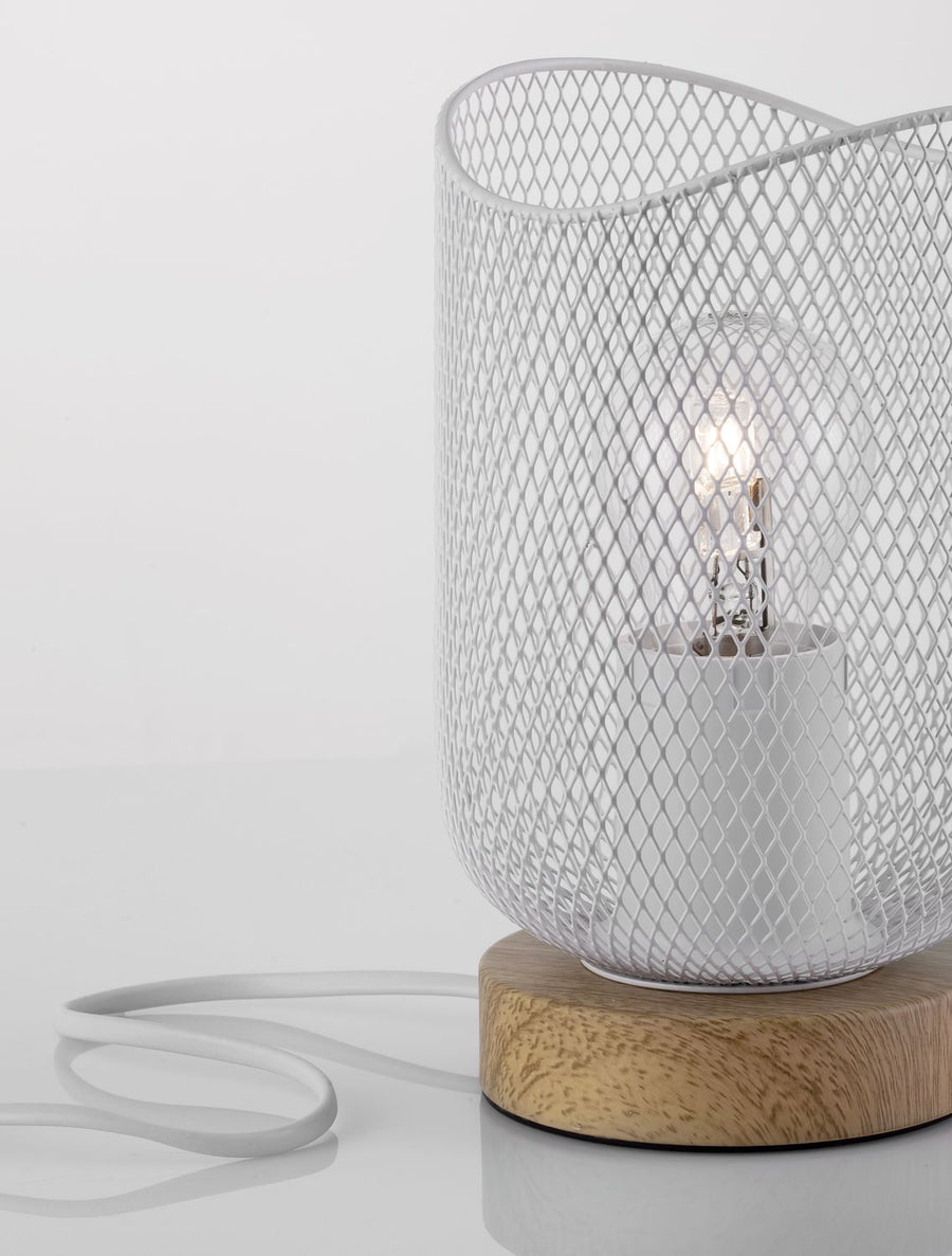 Lampe à poser vue de trois quarts, abat-jour en maille blanche éclairé sur base en bois.
