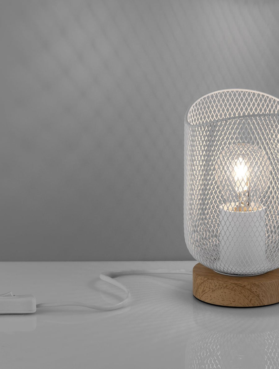 Détail de la lampe à poser, abat-jour en maille blanche et socle en bois, éclairage allumé.