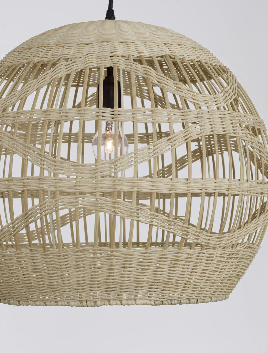 Gros plan sur le tressage en rotin beige et la douille noire avec ampoule à filament