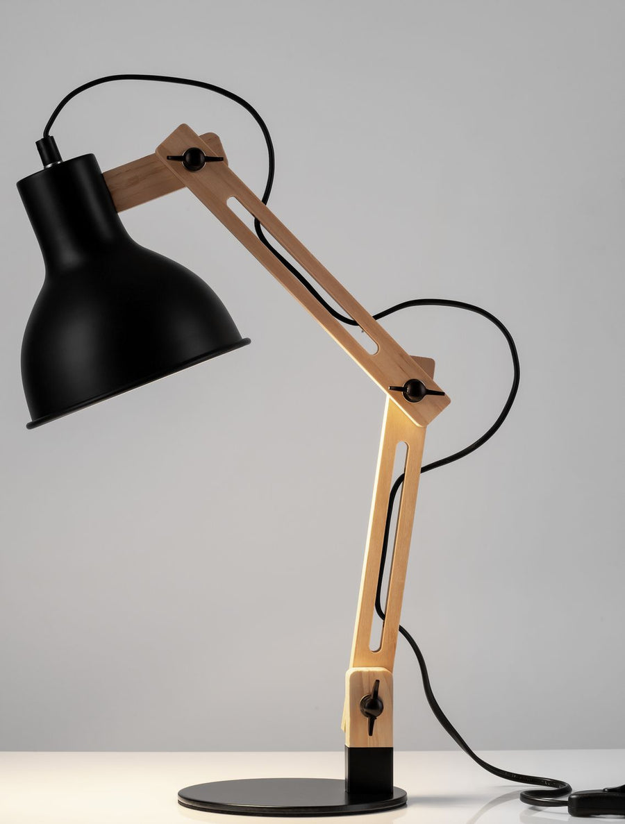 Profil de la lampe sur fond gris, câble noir et base ronde visibles
