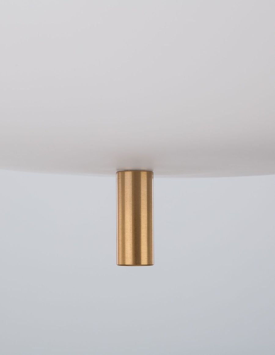 Détail de la rosace dorée fixée au plafond, vue rapprochée de la fixation.
