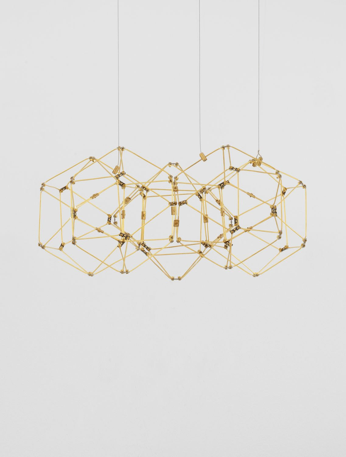 Vue de face sur fond blanc de la suspension dorée entièrement ajourée