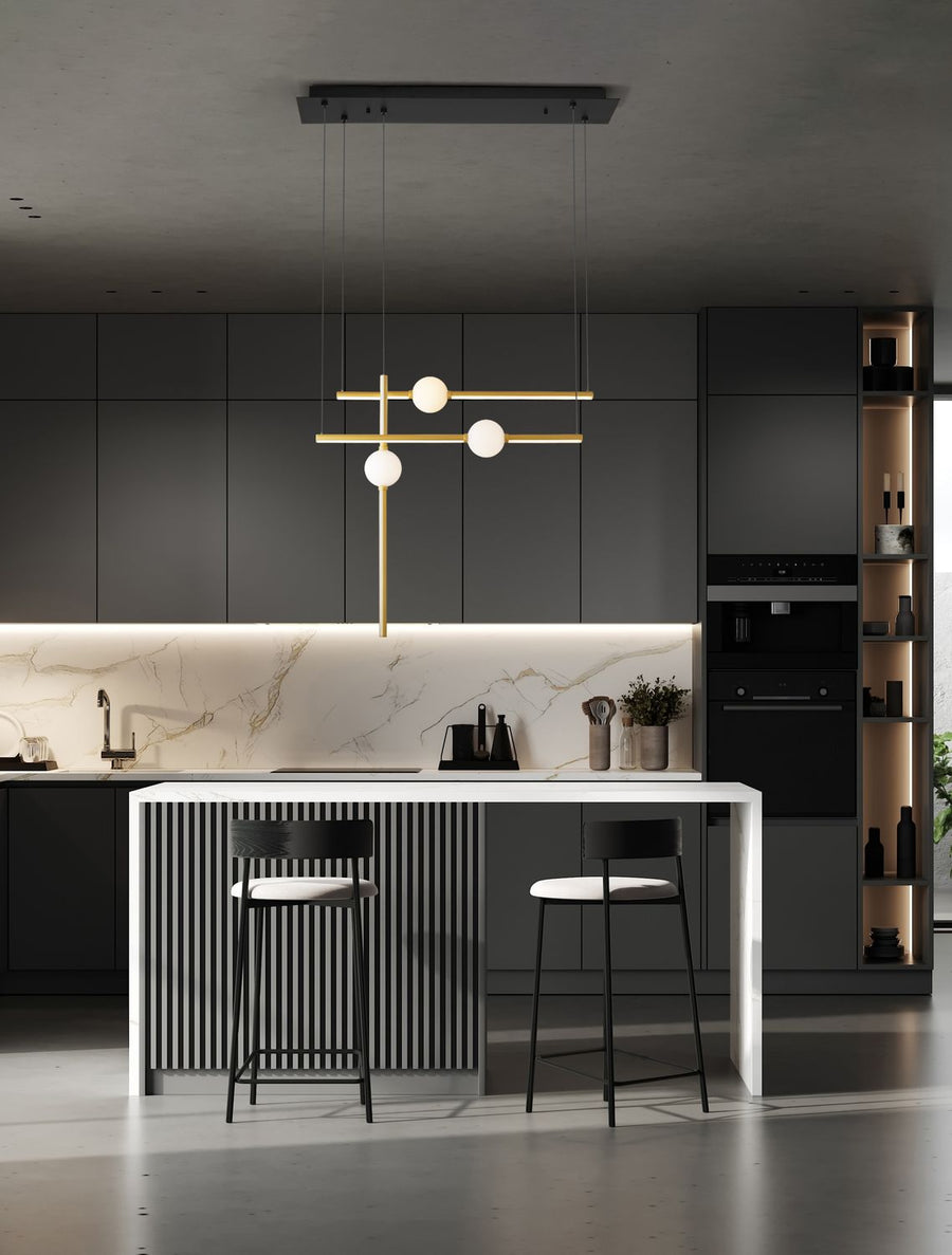 Suspension dorée à trois globes éclairés, installée au-dessus d'un îlot de cuisine contemporaine
