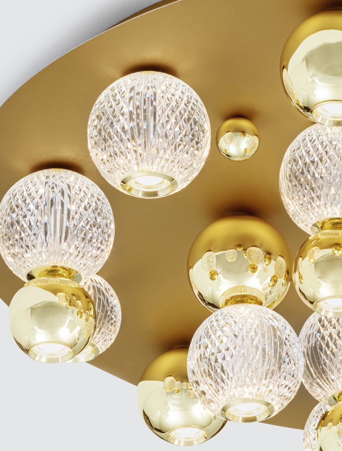 Détail rapproché du plateau doré et des globes de verre facetté suspendus