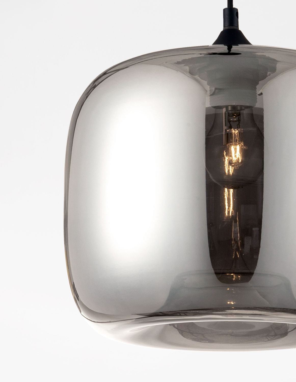 Détail rapproché du verre fumé et de l'ampoule allumée dans la suspension noire