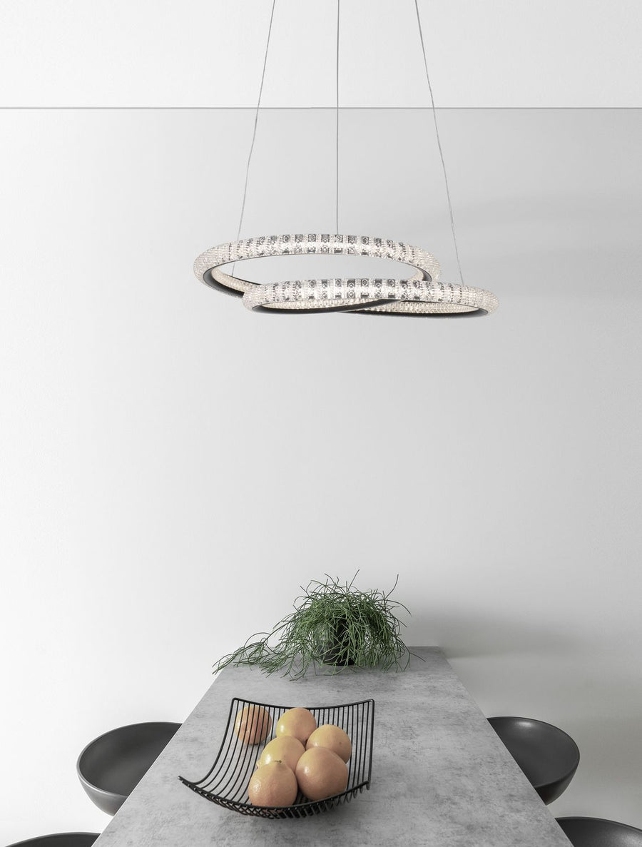 Suspension allumée au-dessus d'une table à manger, décor contemporain en tons gris