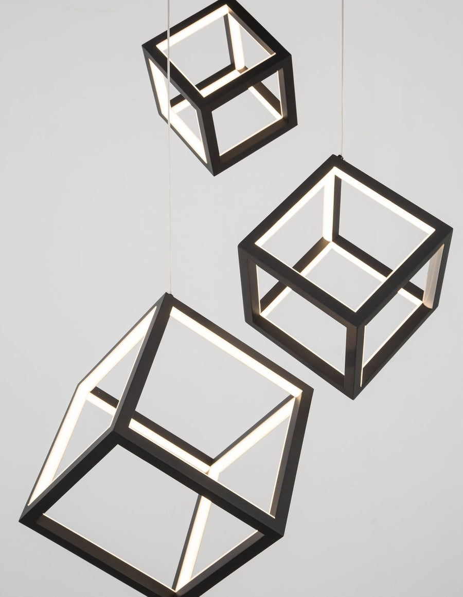 Gros plan sur deux cadres cubiques éclairés, finition noire mate et lumière chaude