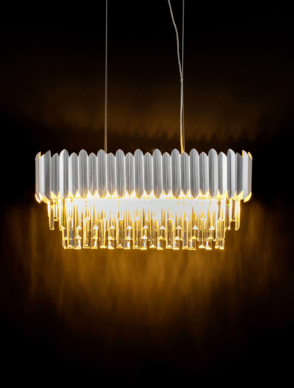 Mise en ambiance sombre, suspension allumée projetant une lumière dorée