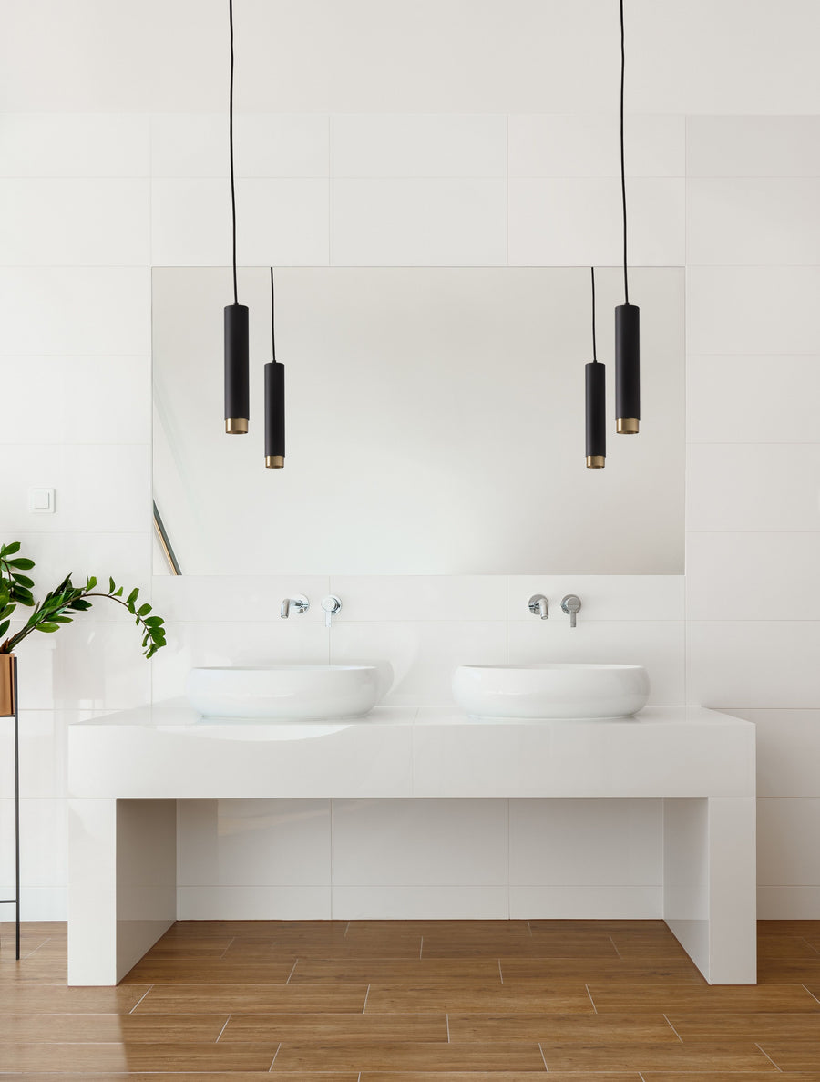 Deux suspensions noires au-dessus d'un meuble vasque double dans une salle de bain claire
