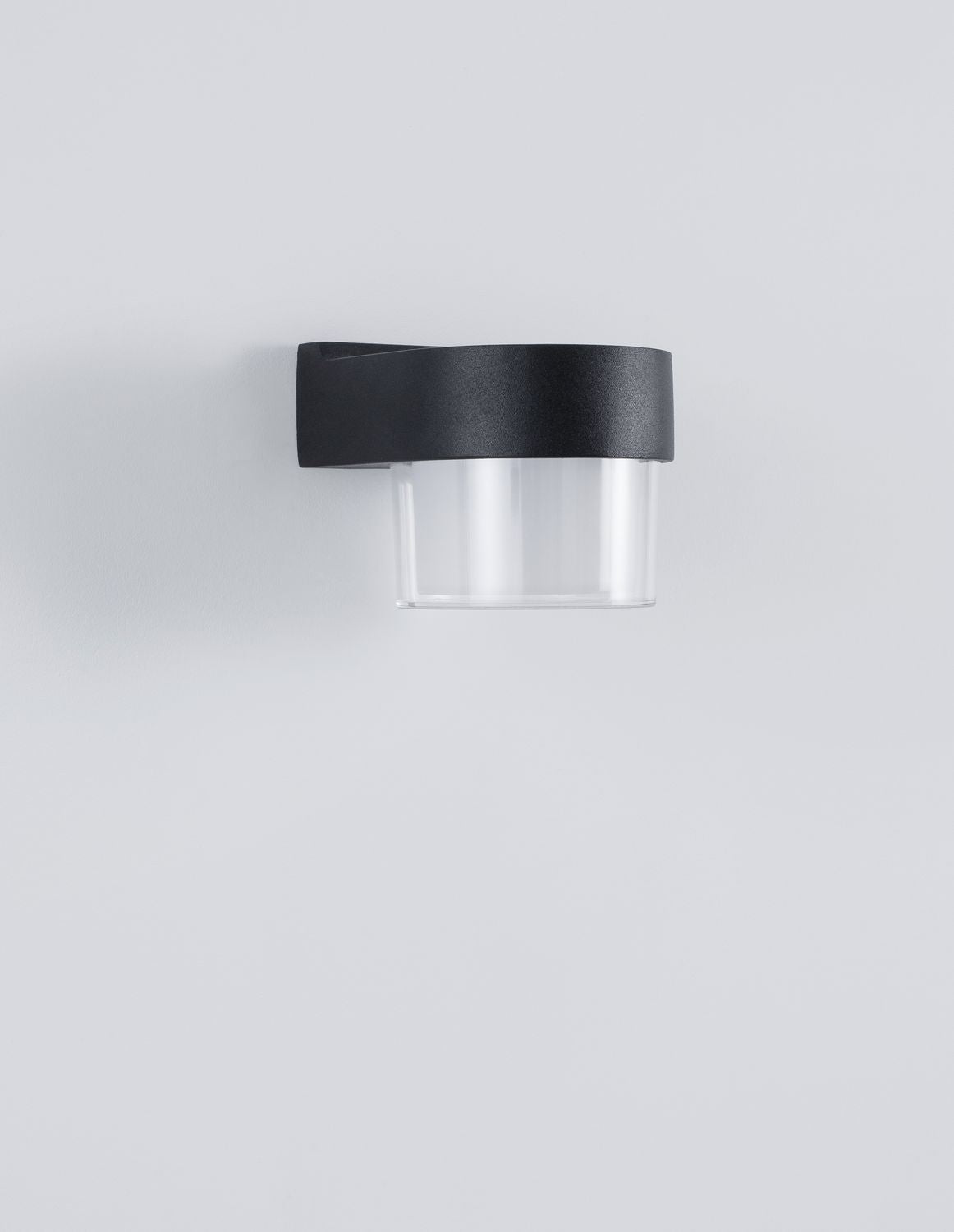 Vue de trois quarts du luminaire éteint, capot noir et verre clair