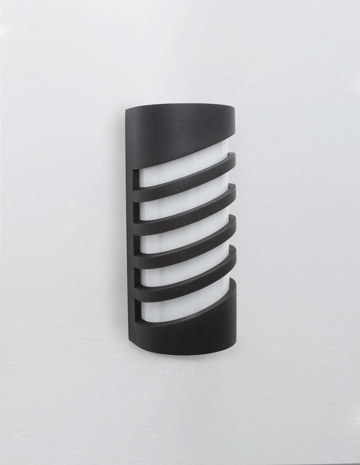 Produit de face éteint sur mur blanc, diffuseur opalin et lames horizontales.