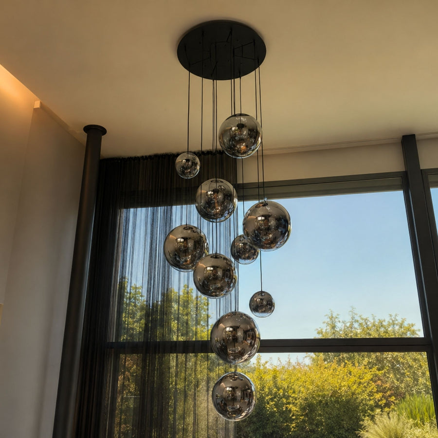 Suspension devant une fenêtre avec rideaux et ciel bleu dégagé.