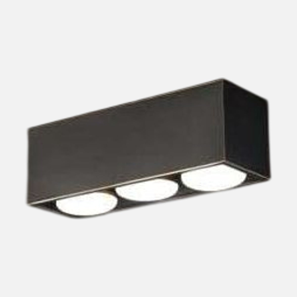 Plafonnier rectangulaire noir incliné montrant trois diffuseurs ronds blancs alignés.