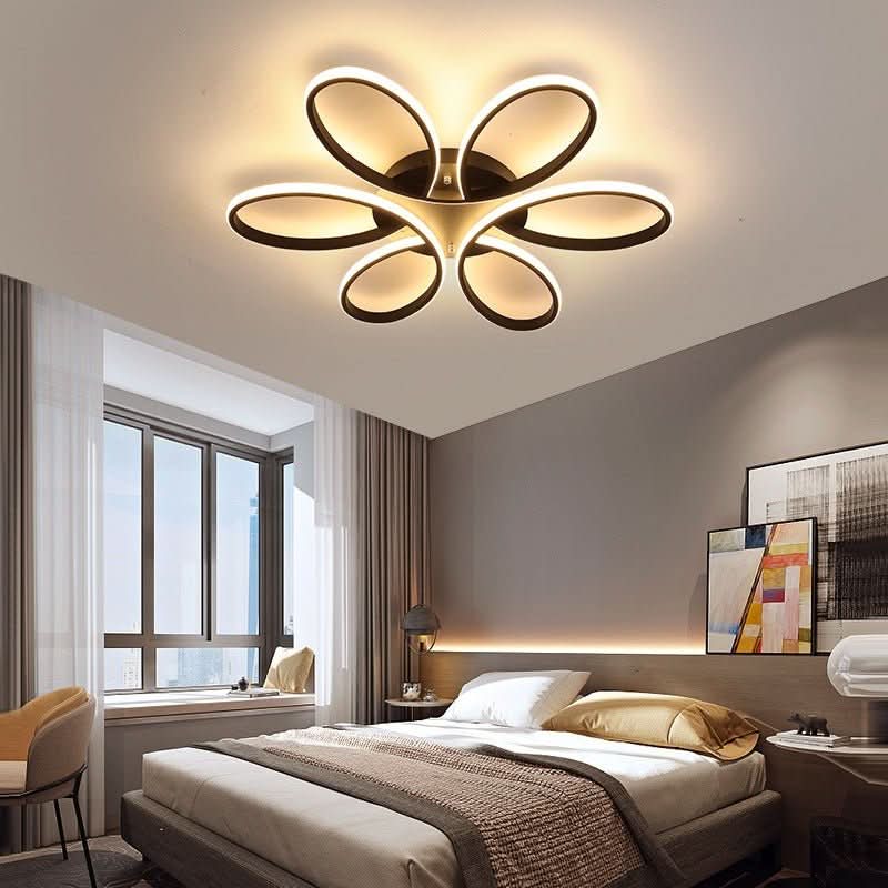 Plafonnier doré à cinq boucles lumineuses installé au plafond d'une chambre moderne