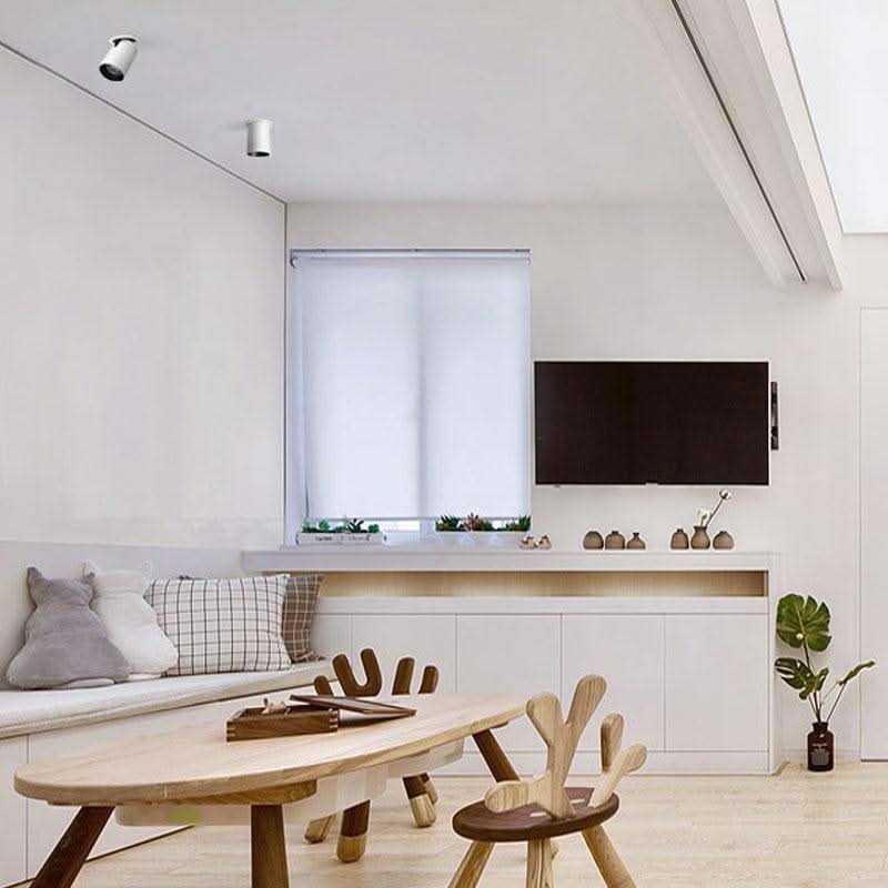 Mise en ambiance : deux spots blancs au plafond éclairent un salon et une table basse.