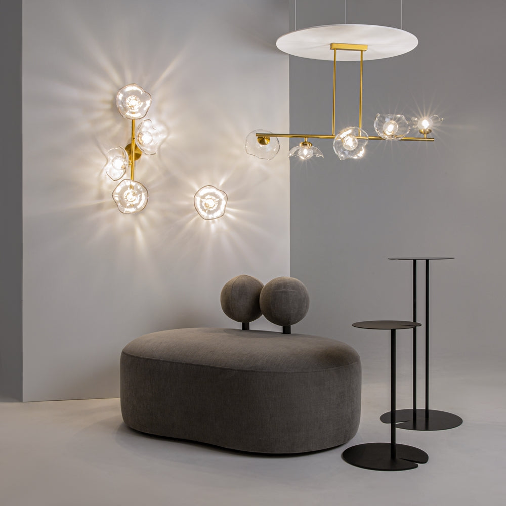 Mise en ambiance avec appliques murales et suspension dorée dans un intérieur gris.