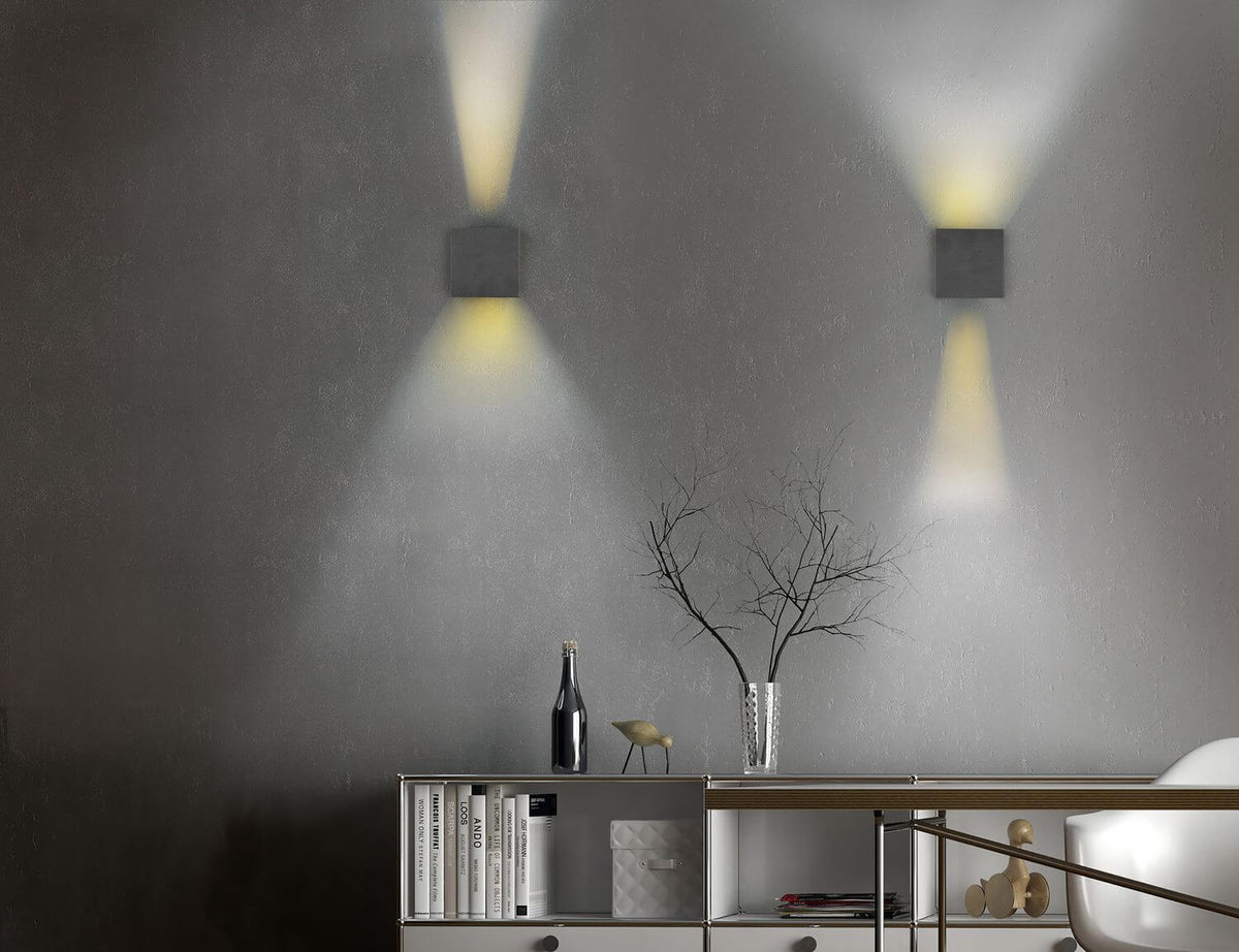 Mise en ambiance de deux appliques noires sur un mur gris, lumière haut et bas