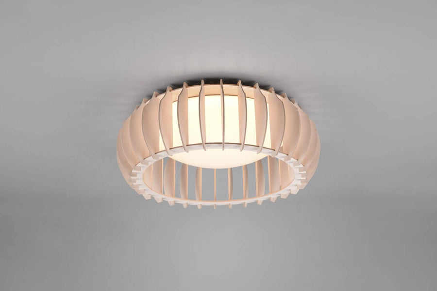 Vue rapprochée du plafonnier allumé, lamelles verticales courbes et diffuseur central lumineux