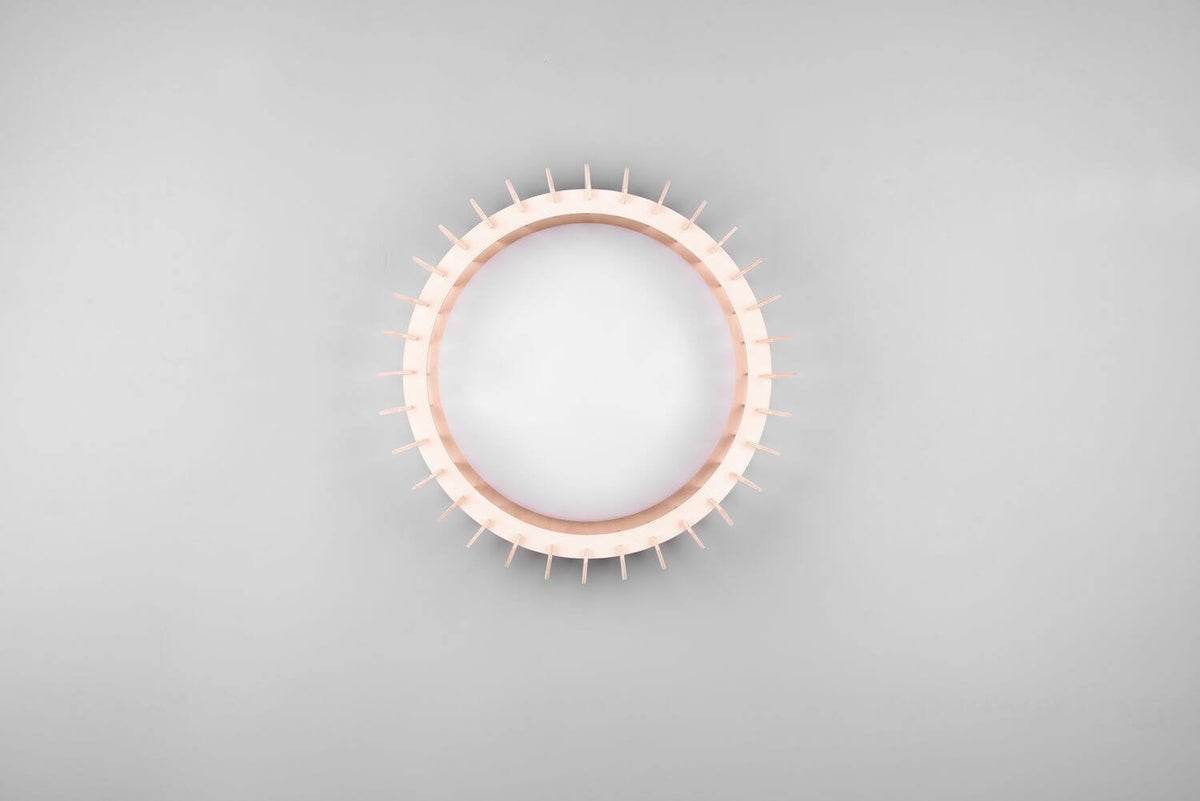 Vue frontale du plafonnier éteint, anneau crénelé beige et grand diffuseur blanc