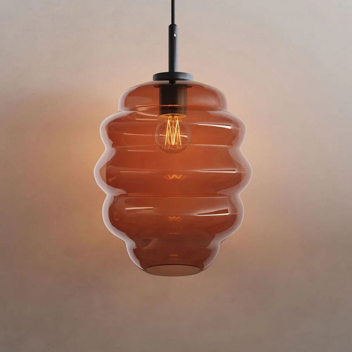 Verre ambré orangé de face soulignant la teinte cuivrée et le filament lumineux.
