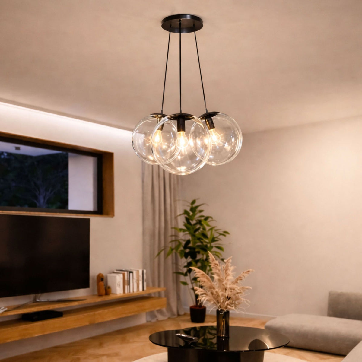 Vue en salon : trois globes transparents éclairés au-dessus d'une table basse