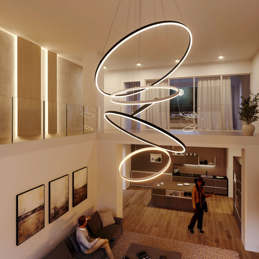 Grande suspension composée d'anneaux noirs superposés en spirale dans un loft contemporain.