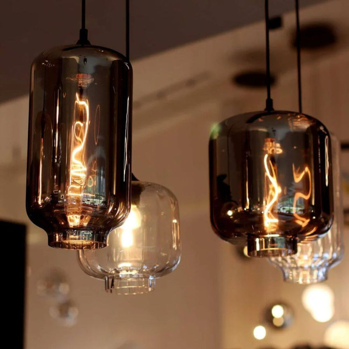 Détail de deux verres suspendus, ampoules filament torsadé bien visibles à travers le verre