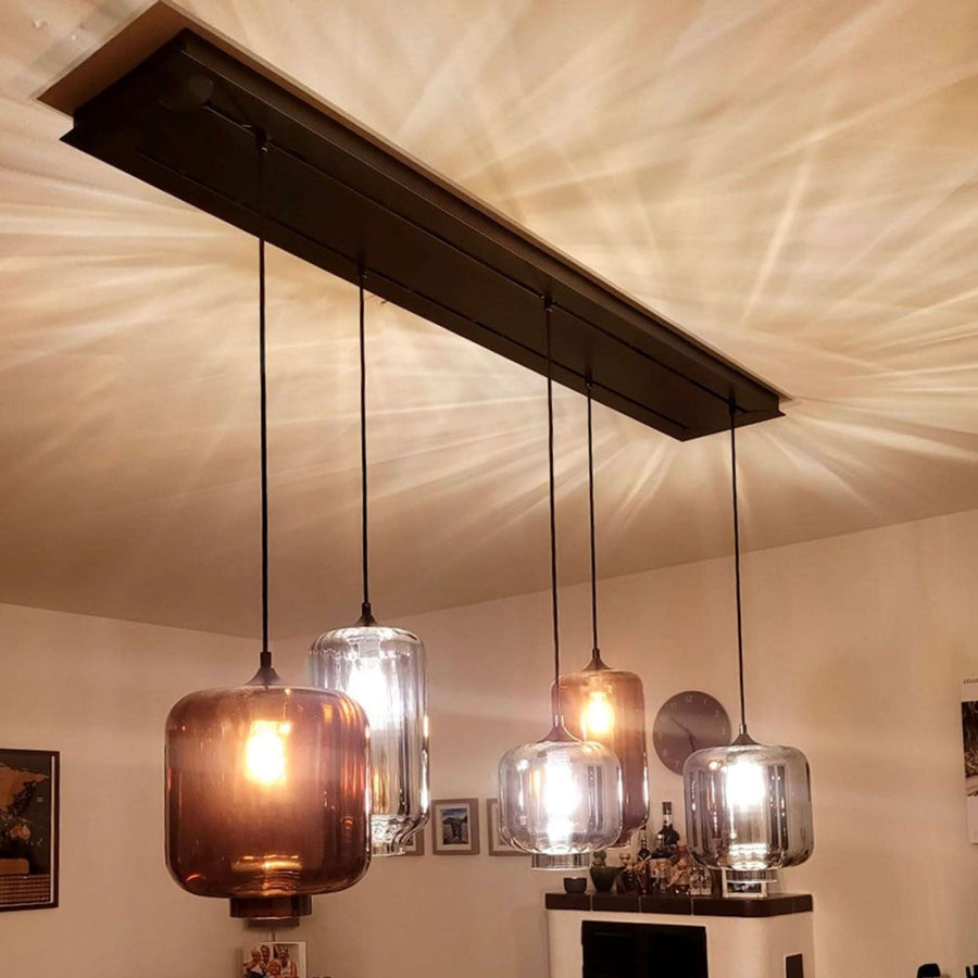 Vue en contre-plongée du luminaire allumé projetant des ombres rayonnantes au plafond