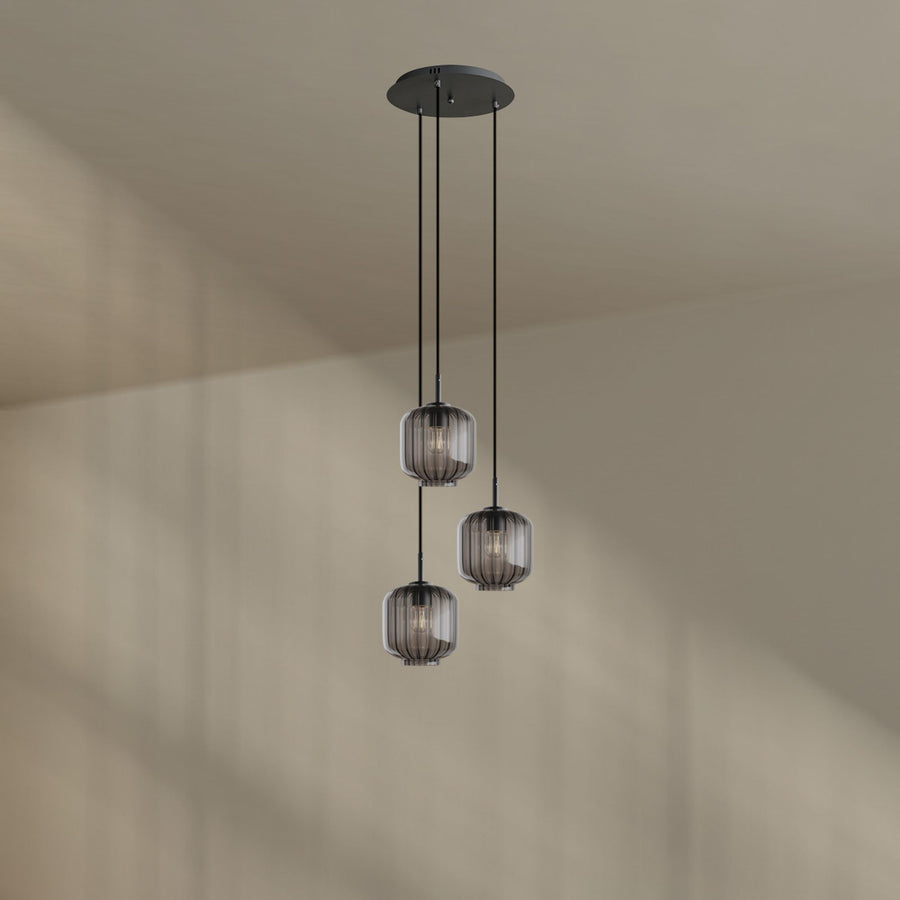 Suspension aux verres fumés gris clair suspendue devant un mur beige