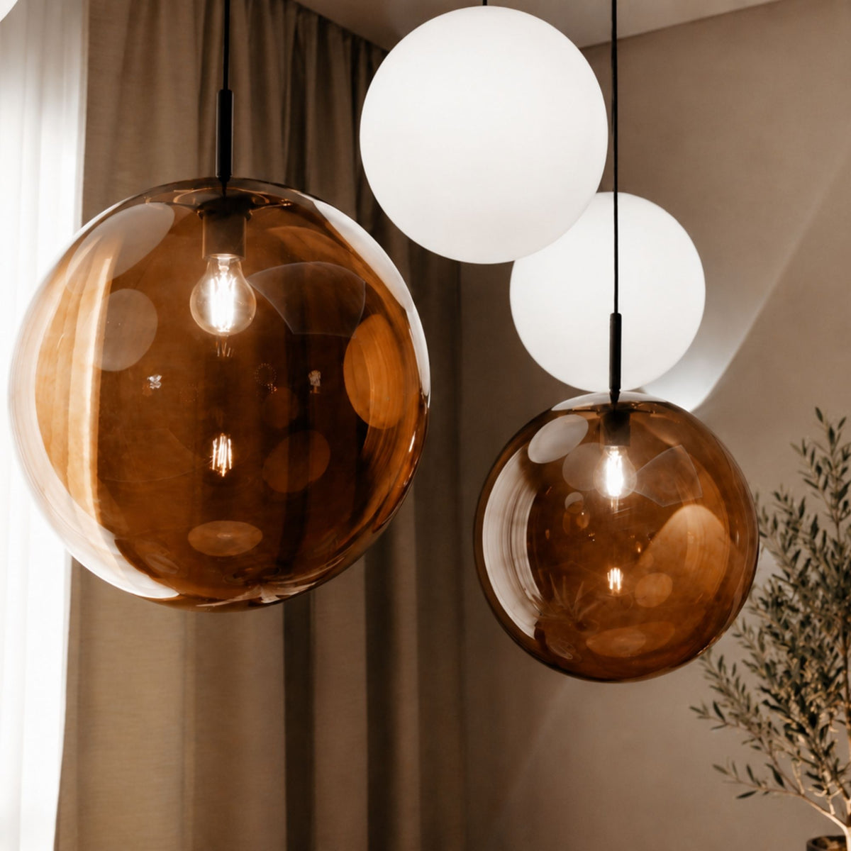 Gros plan sur deux globes en verre ambré et opalin laissant voir les ampoules