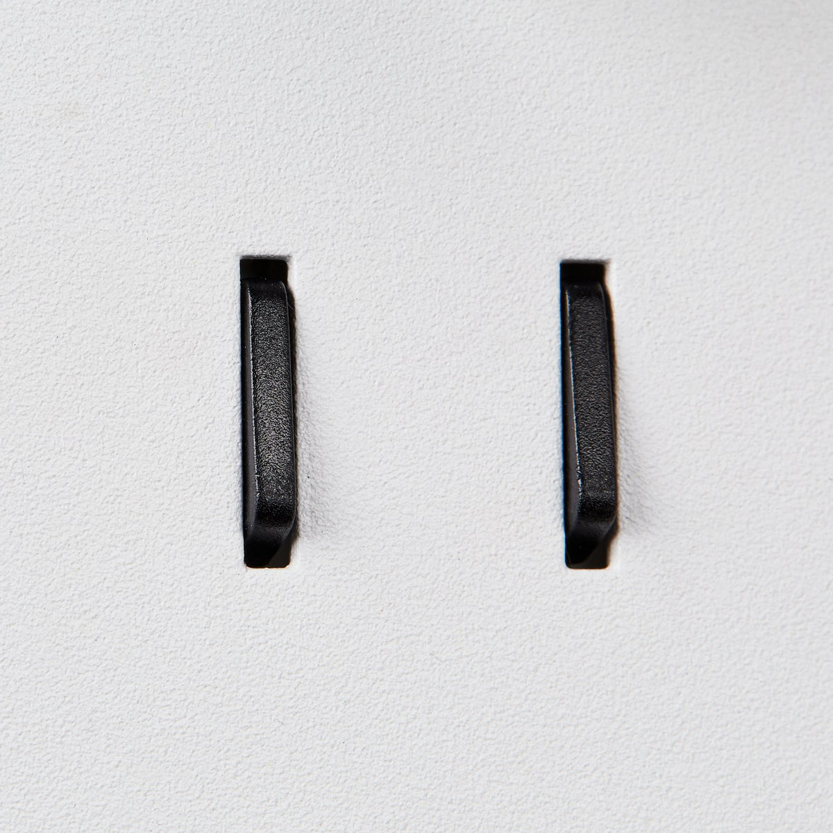 Détail des deux interrupteurs noirs sur la platine murale blanche.