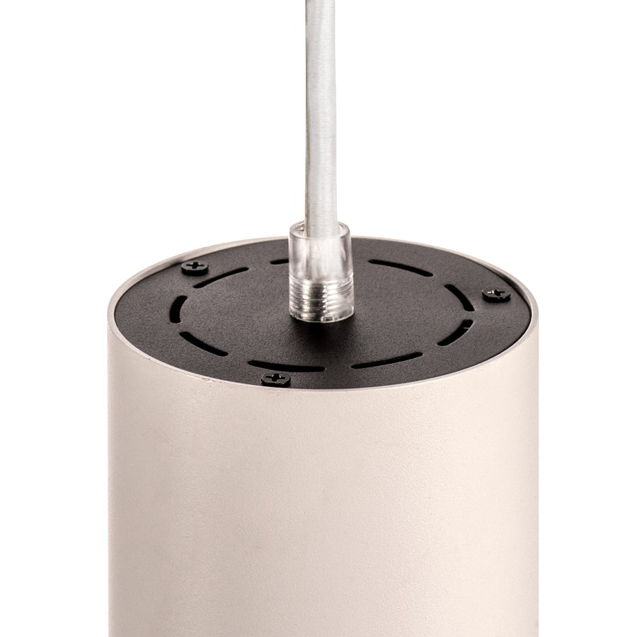 Détail du dessus du cylindre blanc : disque noir perforé et câble transparent.