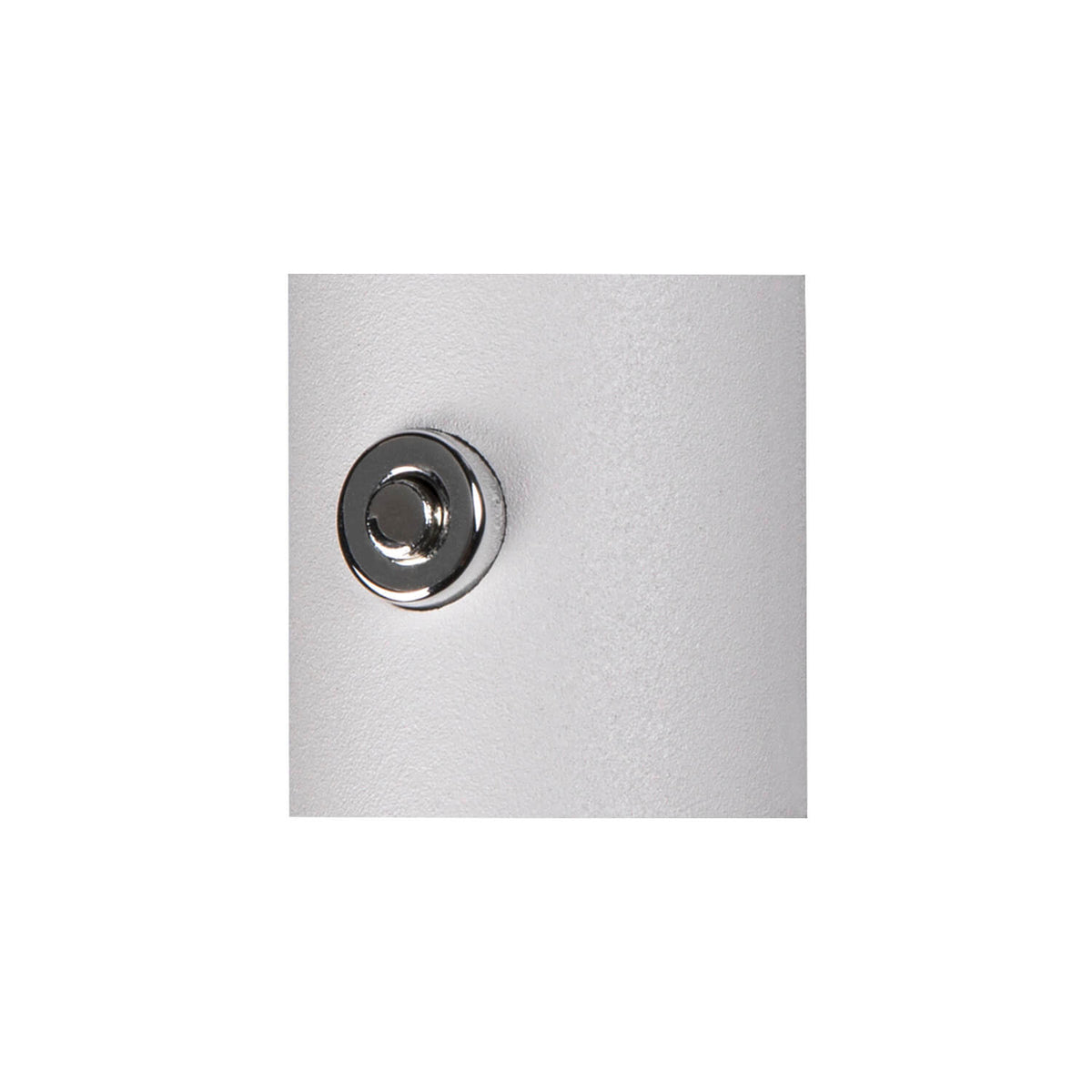 Gros plan sur le bouton-poussoir chromé intégré à la surface blanche mate de l'applique.