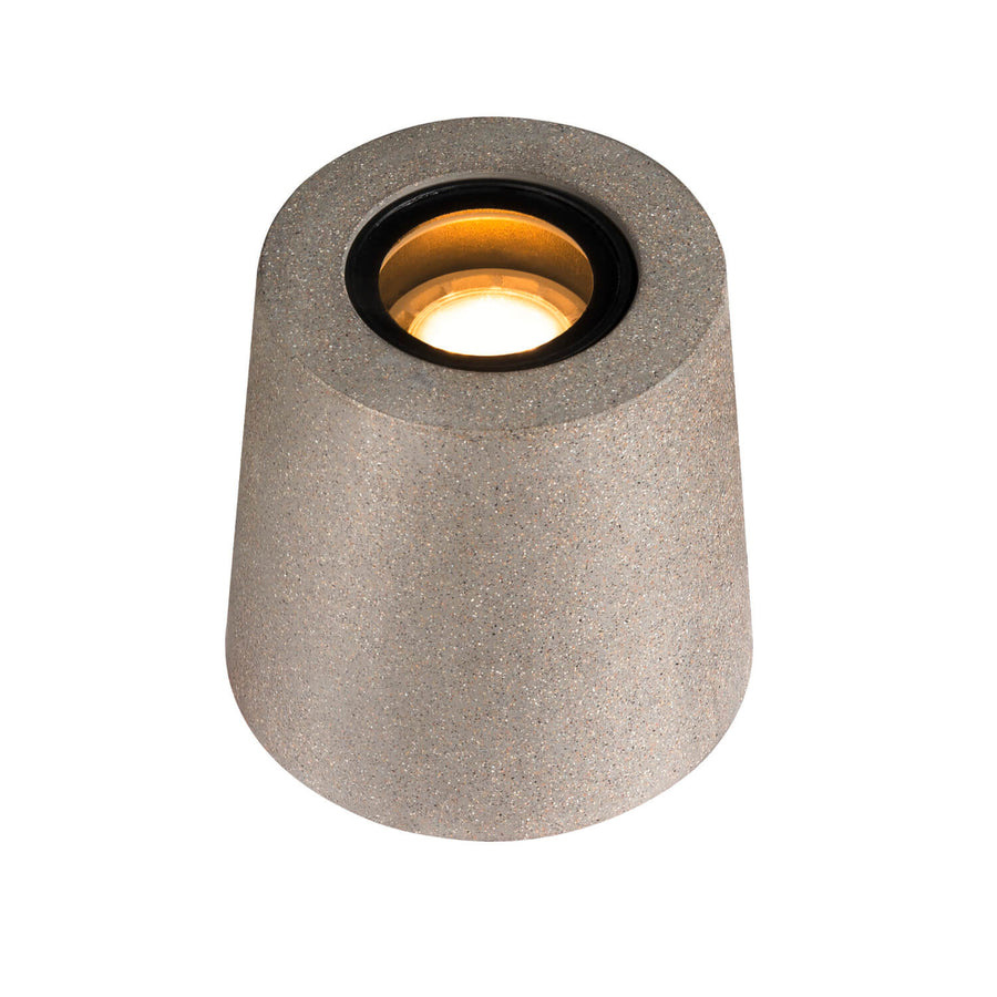 Vue rapprochée du luminaire allumé, montrant l'ouverture circulaire et la lumière chaude.
