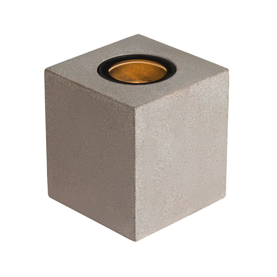 Vue de face du cube en béton gris avec halo lumineux doré sur le dessus.