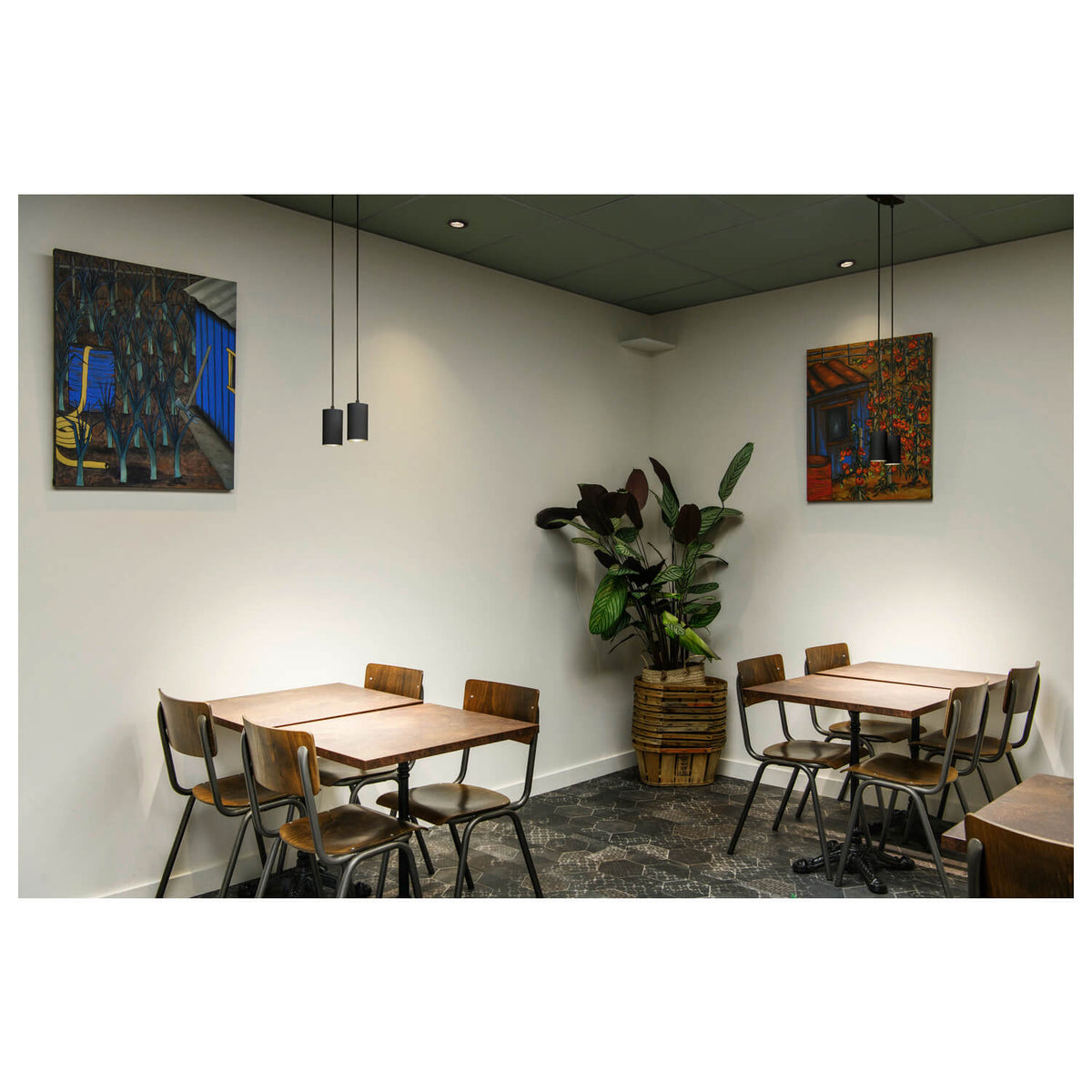 Mise en ambiance dans un café avec la suspension au-dessus de tables en bois.