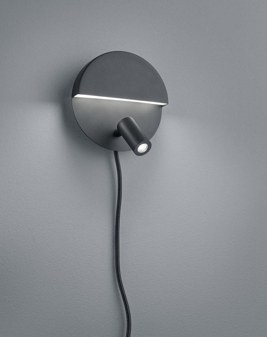Vue de trois quarts sur mur gris avec câble d'alimentation noir apparent