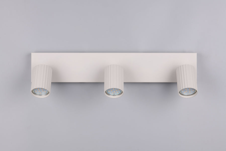 Vue de face du spot plafond blanc avec trois têtes cylindriques cannelées.